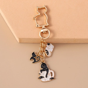 Detailed close-up of cute cat enamel charms with golden metal clasp for backpacks