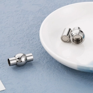 Macro view of silver vacuum-plated stainless steel magnetic jewelry clasps on ceramic