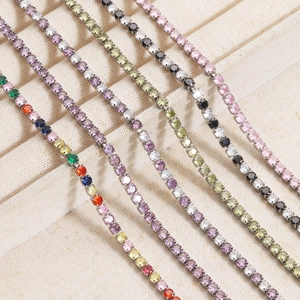 Colorful zircon tennis necklaces in silver-tone settings displayed on a beige tray
