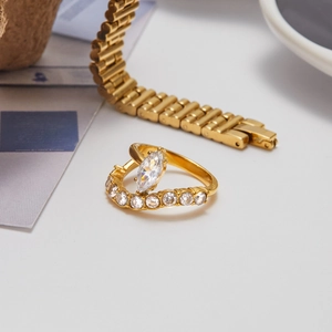 Golden titanium steel ring with marquise zircon and side row diamonds on metal strap background