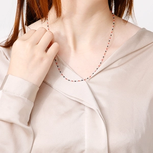 Collana bohémien in acciaio al titanio con perline rosse e nere su una modella