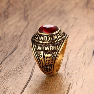 Détail macro d'une bague aigle vintage plaquée or avec zircon rouge et gravure militaire