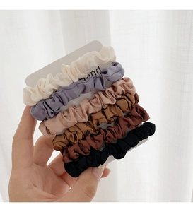 Dettaglio di set da 6 elastici in raso colori Morandi con elegante texture a pieghe