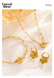 Detailed view of golden flower jewelry set with paperclip chains and toggle clasp