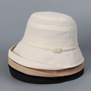 Detail of stacked woven sun hats showing texture in beige, khaki, and black colors