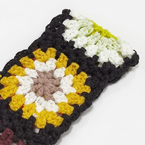 Close-up of handmade crochet sunflower patterns with intricate knit textures on bag