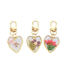 Heart-shaped resin keychains with real dried flowers and gold metal spring clasps