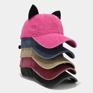 Stack of colorful velvet baseball caps with cute cat ears in pink, navy, khaki, burgundy, and black