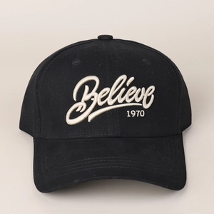 Close-up of white 3D Believe 1970 embroidery on a black cotton baseball cap
