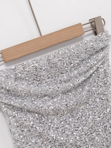 Dettaglio ravvicinato delle paillettes argento scintillanti su un top a fascia appeso