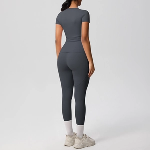Rear view of two-piece dark grey high-stretch yoga set with short sleeve top and leggings