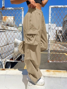 Detail of khaki cargo pants featuring large side flap pockets and adjustable drawstring cords