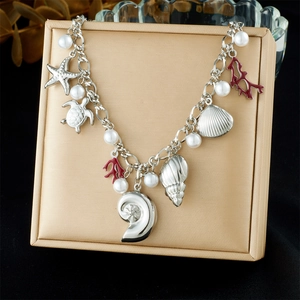 Detailed shot of silver ocean charms with shells and red coral on a linked chain