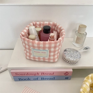 Detailed close-up of a pink checkered quilted fabric organizer basket for skincare products