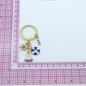 Detail of nautical keychain with lighthouse, ship wheel, lifebuoy and sailboat charms