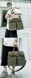 Detail of vintage green canvas messenger bag with leather handles and dual front zip pockets