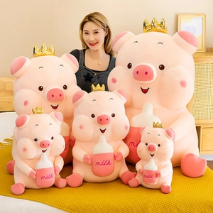 Detail showing a series of pink pig plush toys with golden crowns in various sizes