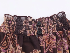 Close-up of bohemian chiffon dress featuring elastic smocked waist and paisley pattern