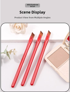Detailed view of three angled brow brushes with metallic red handles and synthetic bristles