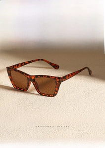 Detail of tortoise shell cat-eye sunglasses with brown lenses and fashion trend text