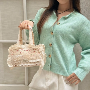 Vue détaillée d'un sac cabas floral en toile avec bordure en dentelle par le mannequin
