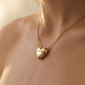 Collier cœur doré PVD avec gravure battement de cœur porté sur un mannequin femme élégant