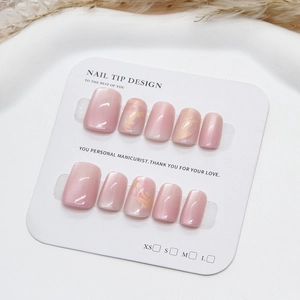 Pink and white gradient handmade press-on nails with golden marbling on a white display card