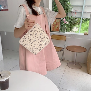 Floral canvas cosmetic bag with purple vintage flowers held by a model in a café