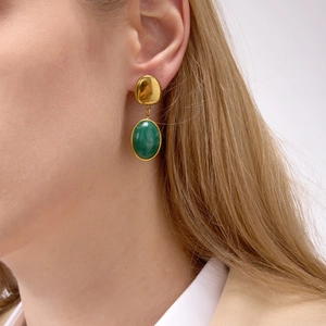 Elegant gold titanium steel earrings with oval green malachite resin pendants on a model
