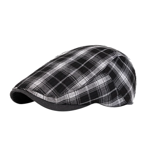 Béret à carreaux noir et blanc classique avec visière noire sur un fond blanc épuré