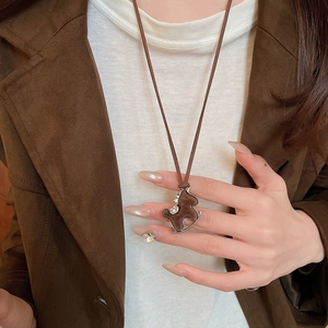 Close-up of a brown flocked rocking horse necklace pendant with sparkling zircon accents