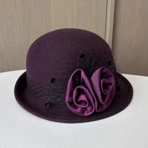 Detail of deep purple wool felt hat featuring elegant satin roses and fine honeycomb mesh