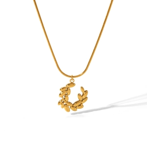 Close-up of golden laurel wreath pendant and delicate snake chain necklace in high detail