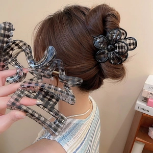 Detail of checkered acrylic hair claw clip and flower-shaped grip on a model's hair