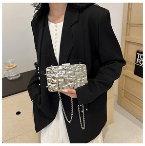 Close-up of metallic silver evening clutch bag with hammer texture and chain strap