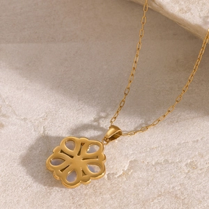 Macro shot of gold-tone hollow floral pendant necklace with inlaid petal detail