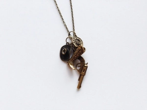 Vintage bronze necklace featuring cowboy hat, boot, revolver, and Good Luck horseshoe charms