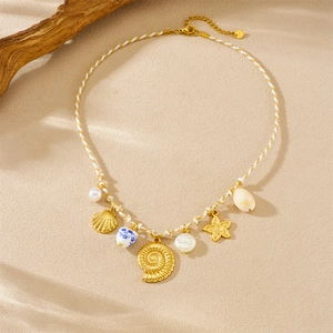Detail of beach necklace featuring starfish, shells, and blue heart pendant on sandy texture