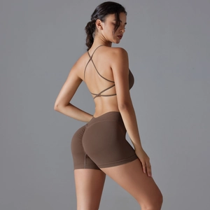 Close-up of brown cross-back sports bra and scrunch butt yoga shorts set on model