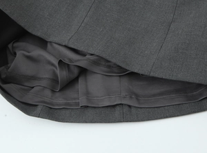 Gros plan de l'ourlet de la robe courte gris foncé montrant la double couche de tissu