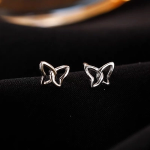 Macro shot of 925 sterling silver butterfly stud earrings on premium black velvet