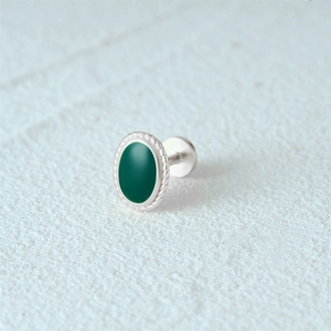 Macro shot of silver earring featuring a green enamel inlay and twisted rope edge detail