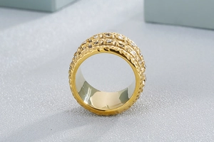 Detailed view of wide gold-tone stainless steel ring with hammered texture and pave stones