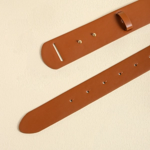 Close-up of brown leather waist belt with gold rivets and metallic buckle details