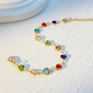 Detail of colorful heart charm bracelet with gold-tone alloy chain and lobster clasp