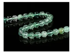 Macro shot of natural green fluorite round beads with internal ice crack textures