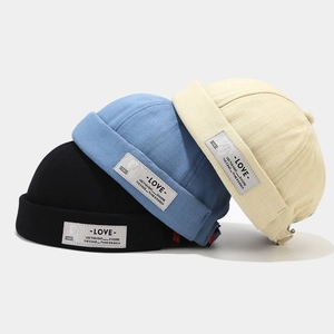 Three cotton canvas docker hats in black, light blue, and beige with adjustable metal buckles