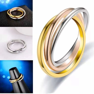 Detail view of interlocking three-color titanium steel rings in gold, silver, and rose gold