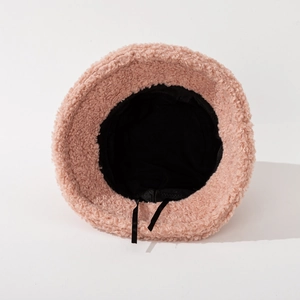 Pink plush teddy fleece bucket hat for winter featuring black lining and adjustable drawstrings