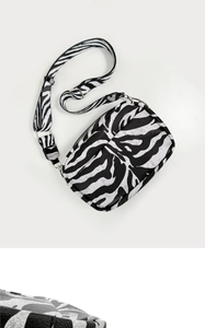 Detail of silver zebra print camera bag showing texture and adjustable strap